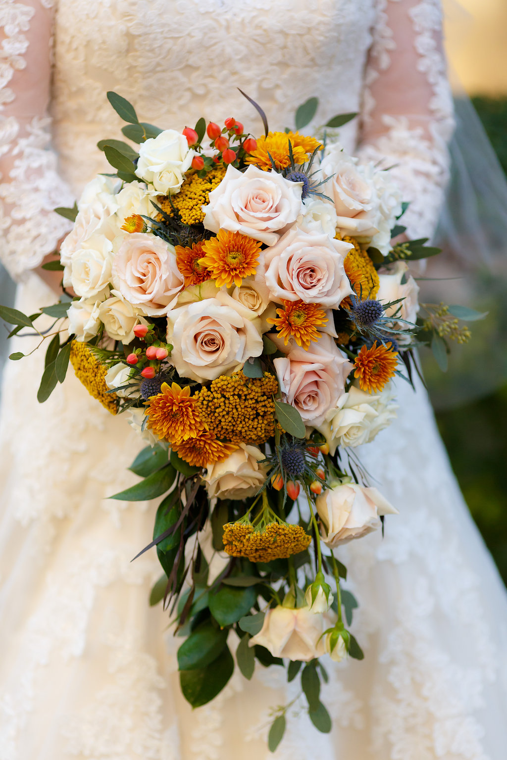 Bride Holding White & Orange Floral Bouquet = Belle Fiori of Milwaukee